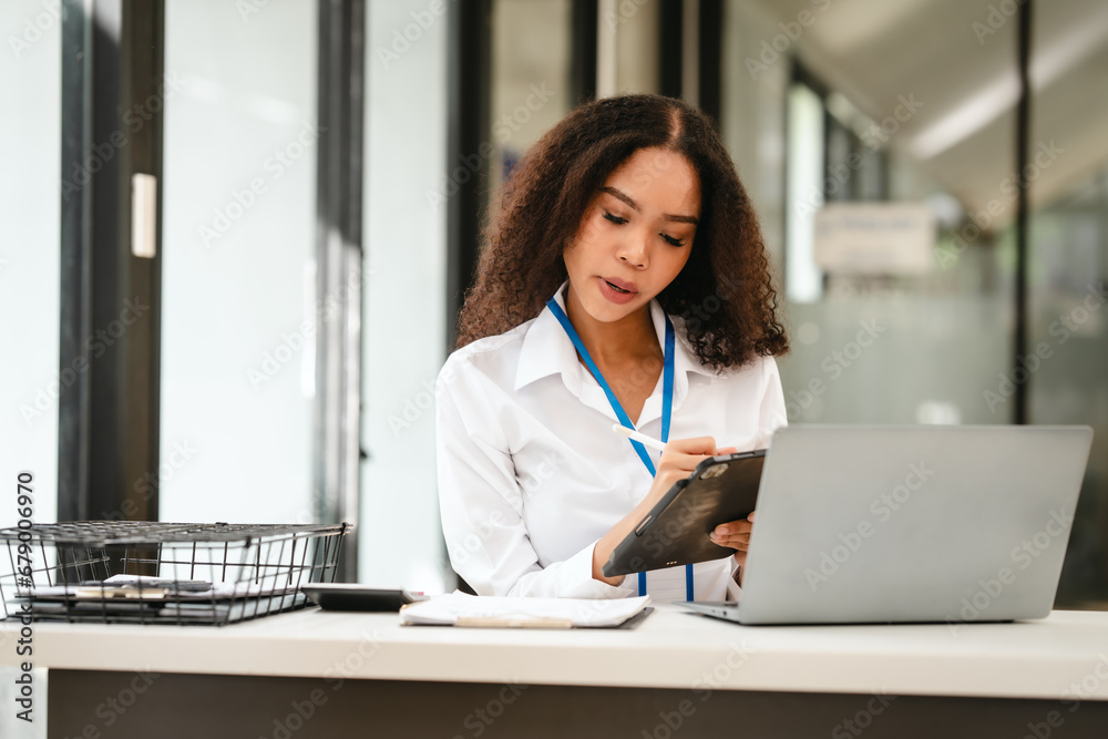African American businesswoman, focused on her work on a laptop, possibly managing industrial production tasks. African American businesswoman, focused on her work on a laptop, possibly managing industrial production tasks.