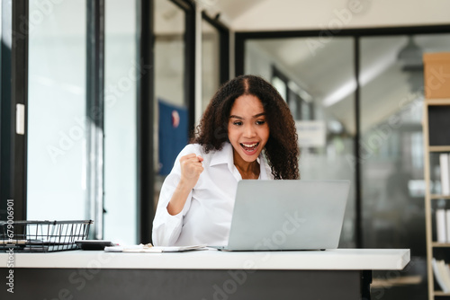 Free Download African American businesswoman, focused on her work on a laptop, possibly managing industrial production tasks. - GFXLoad