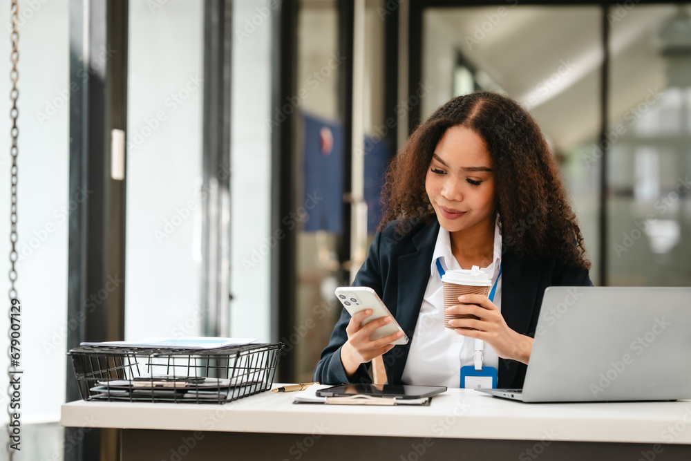 African American businesswoman, focused on her work on a laptop, possibly managing industrial production tasks. African American businesswoman, focused on her work on a laptop, possibly managing industrial production tasks.