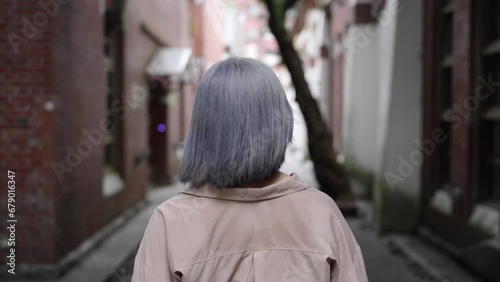 台北の華山1914文創園区の芸術的な建物で歩く若い台湾人女性 Young Taiwanese woman walking in an artistic building in the Huashan 1914 Cultural and Creative Park in Taipei. photo