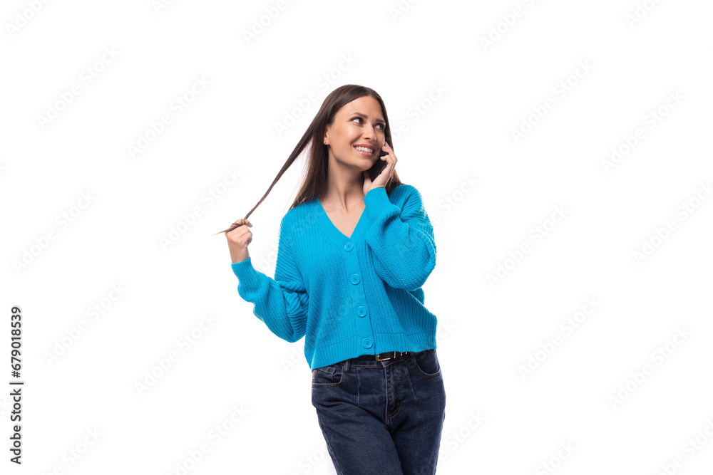 beautiful cute young woman dressed in a blue cardigan chatting on the phone beautiful cute young woman dressed in a blue cardigan chatting on the phone