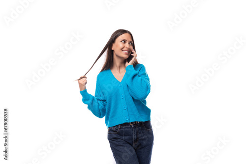 beautiful cute young woman dressed in a blue cardigan chatting on the phone