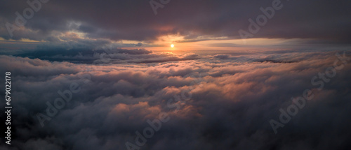 Panorama shot of colorful light of sunrise over rainforest mountains with fog and cloud inversion for natural cinematic of national park and wildlife reserve area © Akarawut