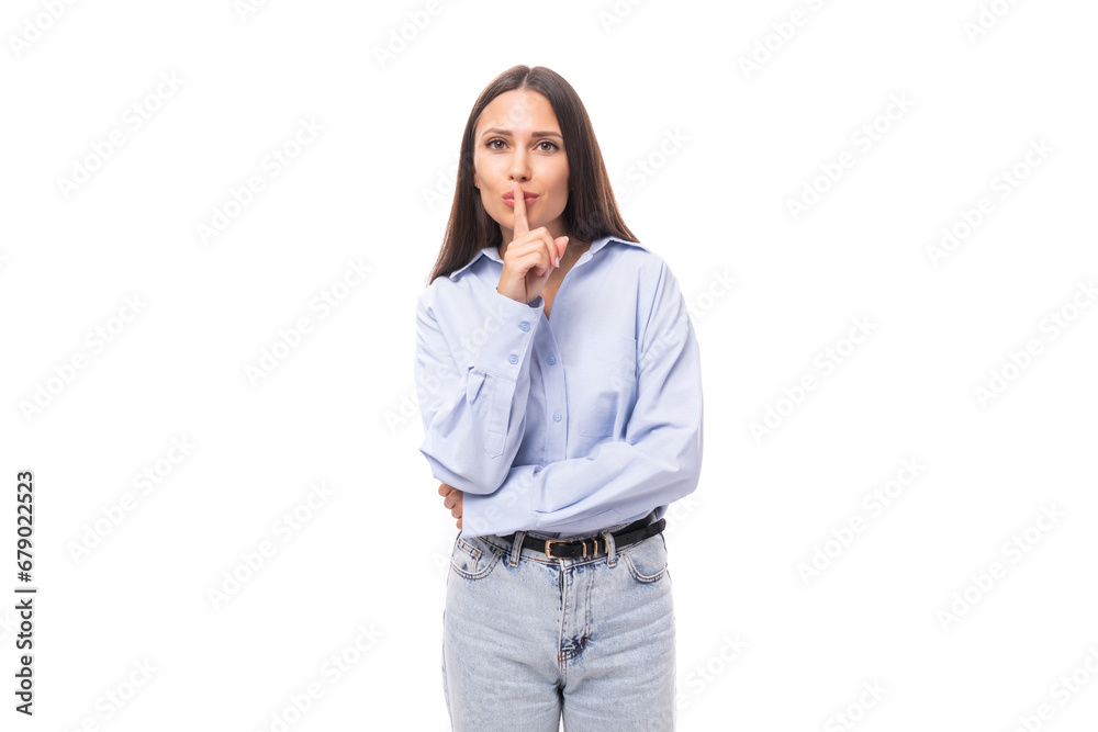 young charming european business woman with long black hair dressed in a blue blouse keeps a secret on a white background with copy space young charming european business woman with long black hair dressed in a blue blouse keeps a secret on a white background with copy space