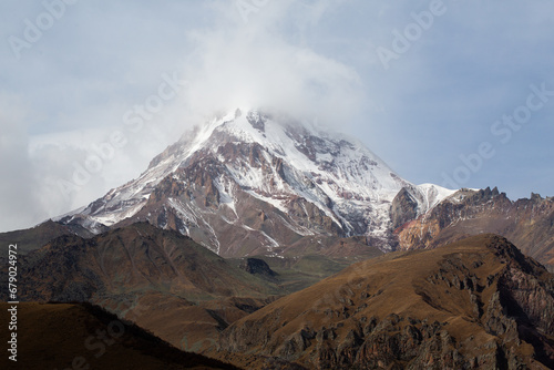 View of Mount Kazbek from the city of Stepantsminda in Georgia in good climbing weather. This is a dormant stratovolcano and one of the largest mountains in the Caucasus.