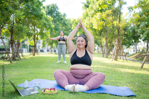 Happy plus size asian woman practicing yoga in garden. Healthy lifestyle and relaxation concept.Young Asian Girl doing yoga in the park.