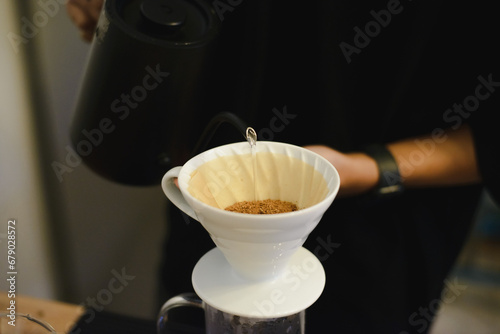 coffee drip, Barista making drip coffee by pouring spills hot water on coffee ground with prepare filter 
