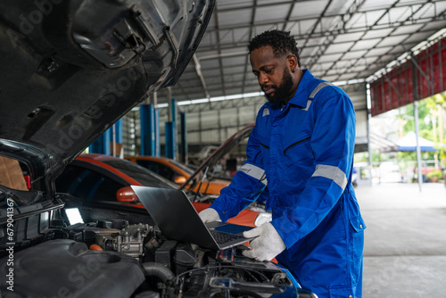 Auto mechanic in blue uniform are repair and maintenance auto engine is problems at car repair shop.