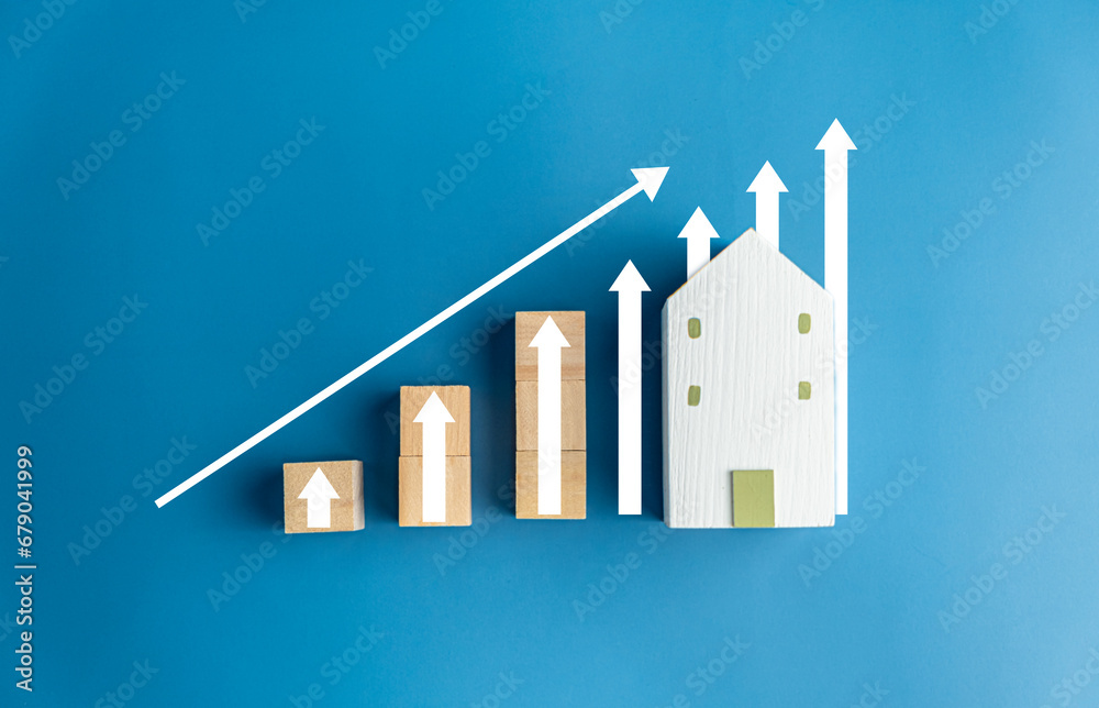 Real estate investment concept. Businessman holding wooden model houses and virtual graph, real estate growth in the future, finance, banking, lending, and trading. - obrazy, fototapety, plakaty 