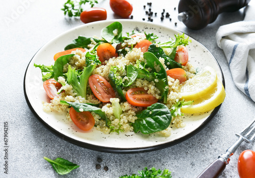 Salad with quinoa tomatoes and spinach on a light background