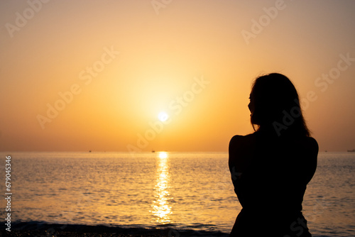 silhouette of a girl on the seashore advertising photo © Alina