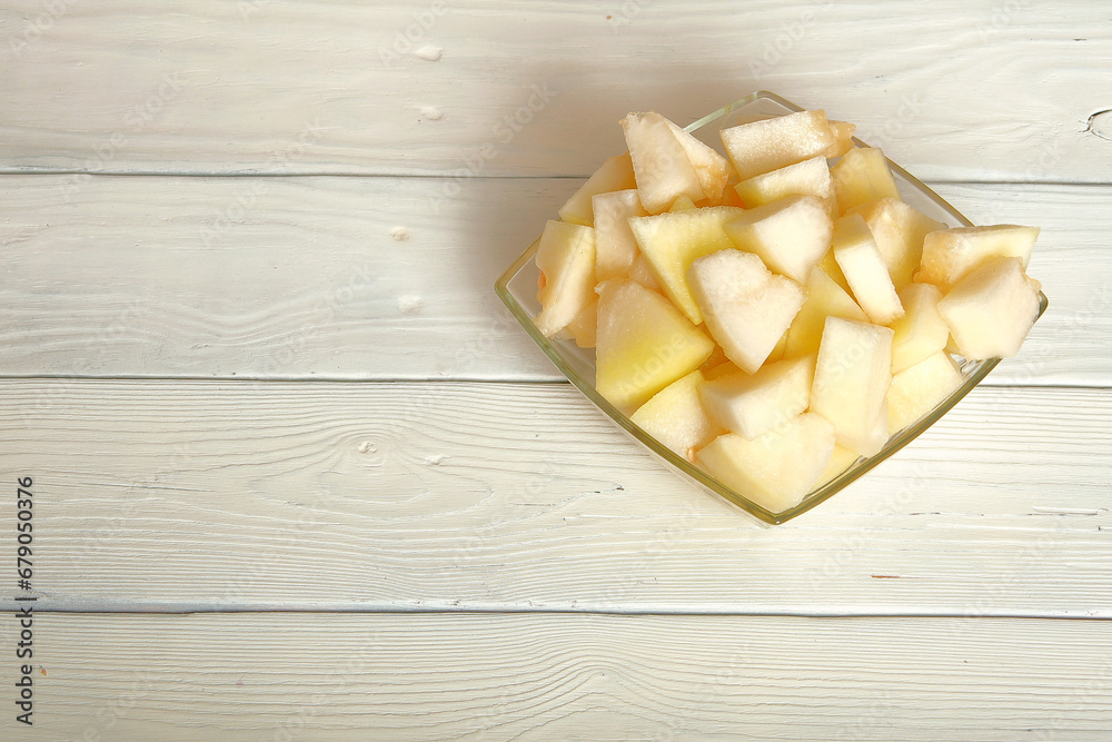 Cut the melon into pieces.on the table is a soft melon, sweet watermelon, cut into large chunks.space for text.table decoration.wooden white background.The concept of the dish.Close-up Cut the melon into pieces.on the table is a soft melon, sweet watermelon, cut into large chunks.space for text.table decoration.wooden white background.The concept of the dish.Close-up
