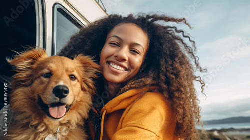 young beautiful woman with her dog beside a camper van