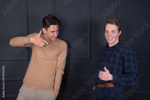 Two young attractive friends are arguing. Gay couple posing in the studio.