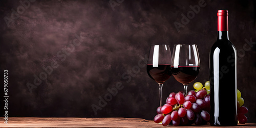 Red wine bottle with wine grapes on black background. photo