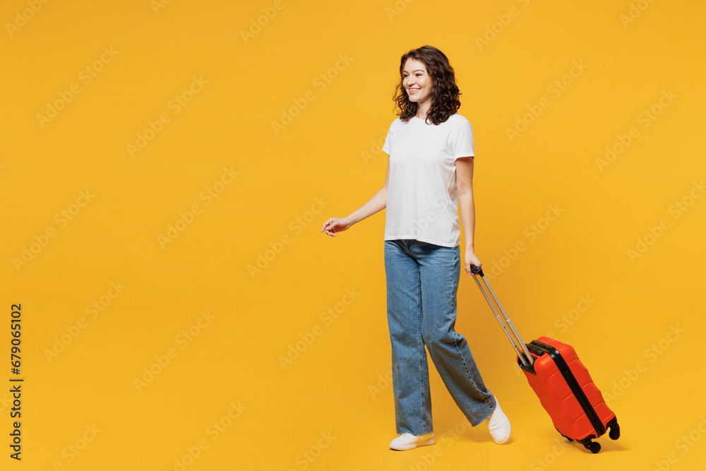 Sideways traveler woman wear t-shirt casual clothes hold suitcase bag walk go isolated on plain yellow background Tourist travel abroad in free spare time rest getaway Air flight trip journey concept Sideways traveler woman wear t-shirt casual clothes hold suitcase bag walk go isolated on plain yellow background Tourist travel abroad in free spare time rest getaway Air flight trip journey concept