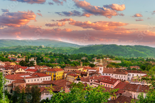 travel summer view from hill to a nice european town with amazing buildings, green hills and mountains with amazing cloudy evening sky on background