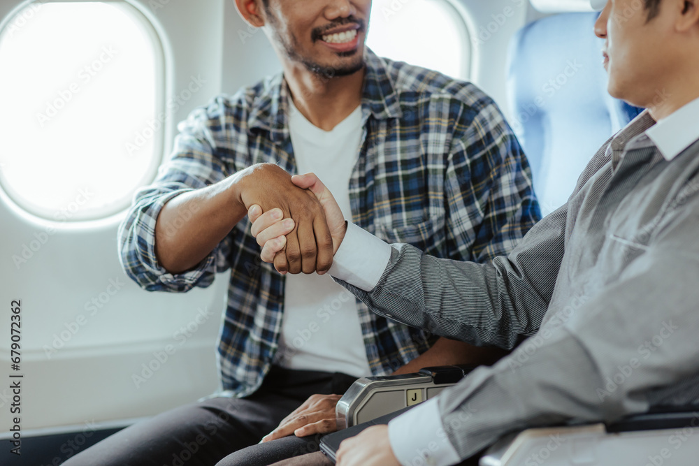 Two business men talking while boarding an airplane Smiling man holding hands