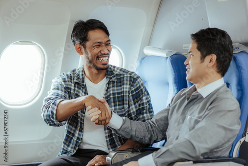 Two business men talking while boarding an airplane Smiling man holding hands