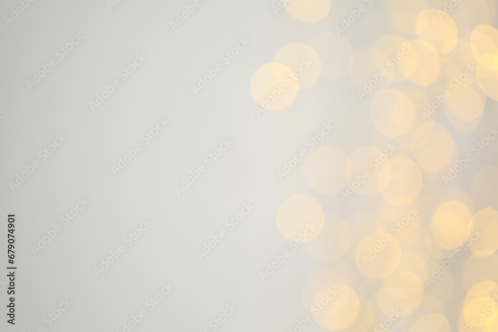 Yellow blurred lights on white background, space for text