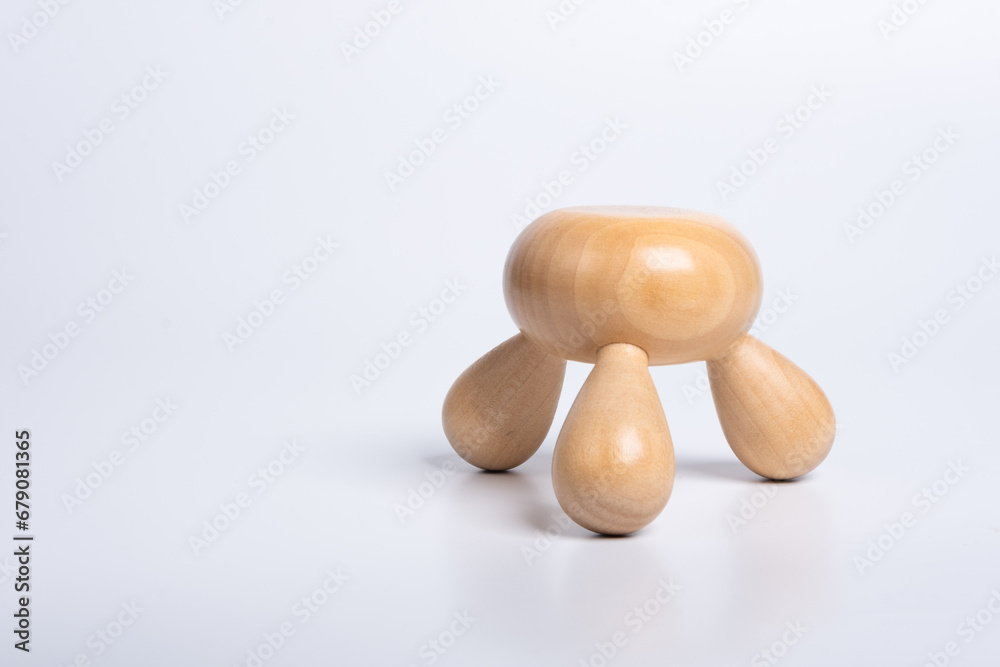 Obraz premium Wooden hands massager on isolated white background. Traditional manual hand massage tool made of wood. Spa and therapy concept. Relaxation. Three Legged