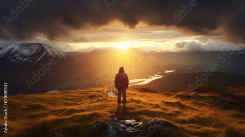 Explorer Watching Sunrise Over Mountain Lake