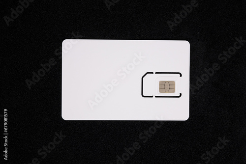 White SIM card isolated on black background. SIM card for mobile phone, top view, close up
