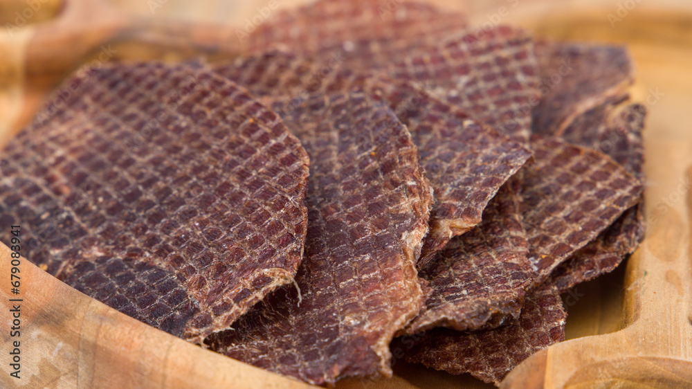 slices of dried beef on a wooden plate