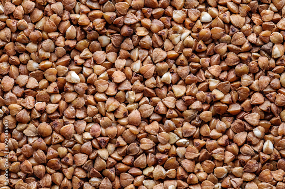 Buckwheat groats in bulk, grains close-up, background Buckwheat groats in bulk, grains close-up, background