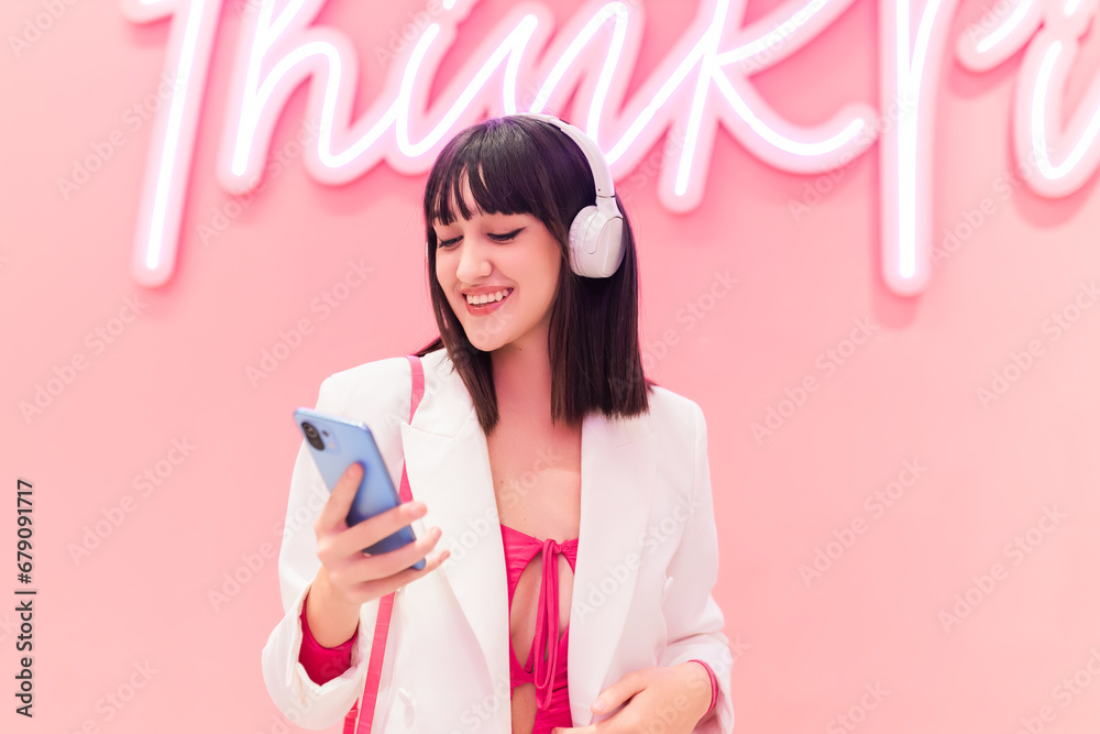 Smiling Asian woman in headphones using smartphone Smiling Asian woman in headphones using smartphone