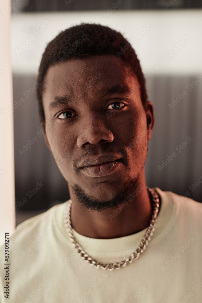 Obraz premium Vertical close up portrait of young Black man looking at camera with serious face expression