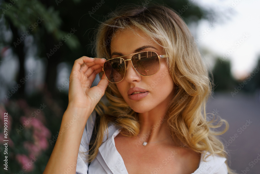 Beautiful blond woman in stylish fashion casual outfit posing on the street. Warm sunset color. Beautiful blond woman in stylish fashion casual outfit posing on the street. Warm sunset color.