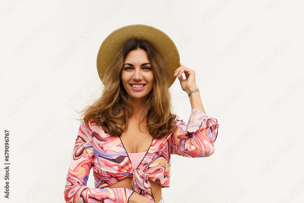 Beautiful european woman in stylish summer outfit and straw hat posing on white background. Fashion look. Beautiful european woman in stylish summer outfit and straw hat posing on white background. Fashion look.