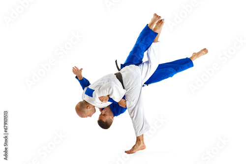 Two professional sportsmen, athletic men in in white and blue uniform performing technical skills while fighting isolated white studio background. photo