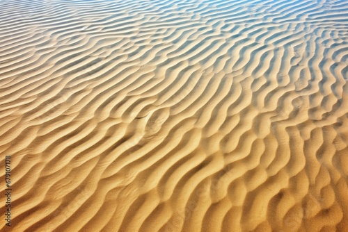sand with a wave pattern under clear blue sky