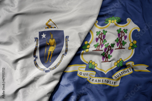 big waving colorful national flag of connecticut state and flag of massachusetts state . photo