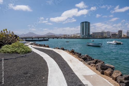 View of the city of Arrecife from the Fermina islet. Turquoise blue water. Sky with big white clouds. Seascape. Lanzarote, Canary Islands, Spain. photo