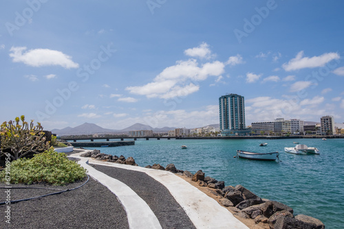 View of the city of Arrecife from the Fermina islet. Turquoise blue water. Sky with big white clouds. Seascape. Lanzarote, Canary Islands, Spain. photo