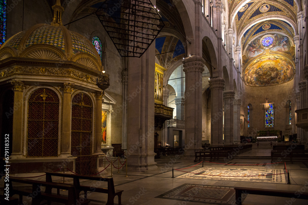 Main nave of the Lucca Cathedral. It is a Roman Catholic cathedral dedicated to Saint Martin of Tours in Lucca, Tuscany, Italy. Interior and ceiling are decorated in golden tones.