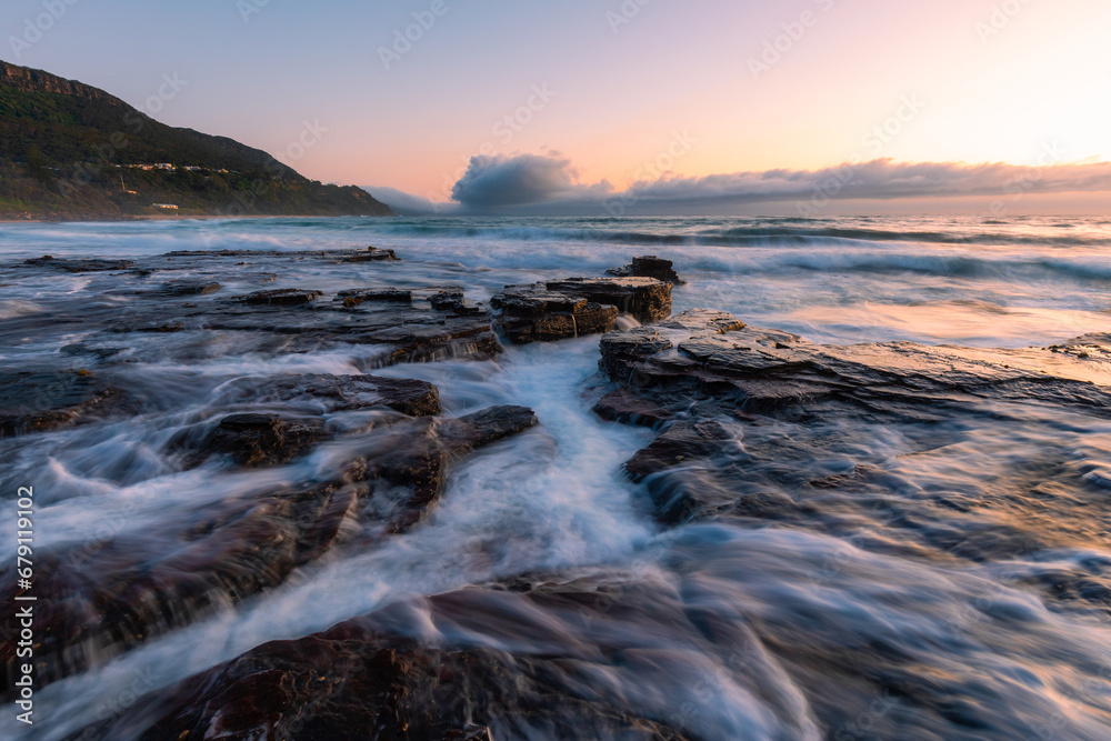 Ocean water flows through rock platforms on the coastline.