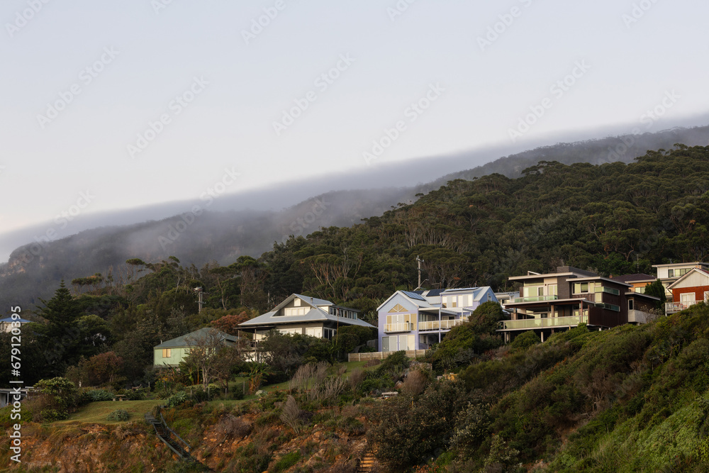 Houses on the hill with foggy sky.