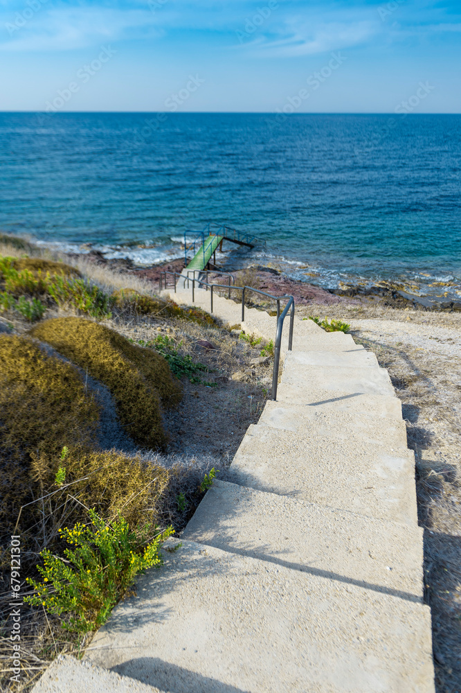 Stairs and wooden pier along the shore in the natural area, sunny autumn day.