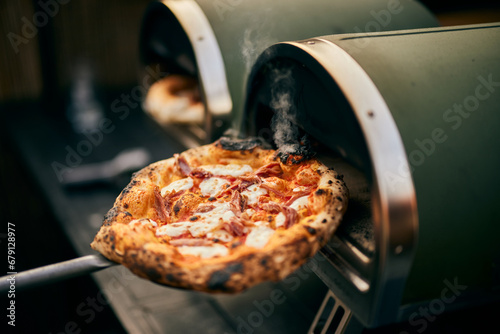 Freshly baked pizza right from the oven, on the pizza shovel. photo