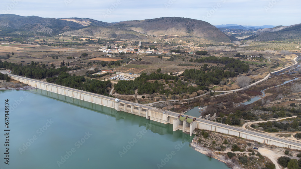 Rear view of the Bellus dam dedicated to containing water for irrigation and against possible floods and in the background the town of Bellus between mountains, in the province of Valencia, Spain