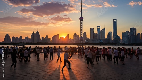 People practice taiji on the bund, oriental pearl tower in the distance, in Shanghai, China photo