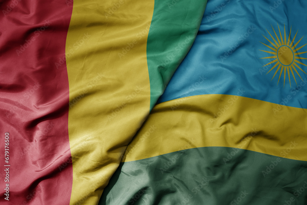 big waving national colorful flag of guinea and national flag of rwanda . big waving national colorful flag of guinea and national flag of rwanda .