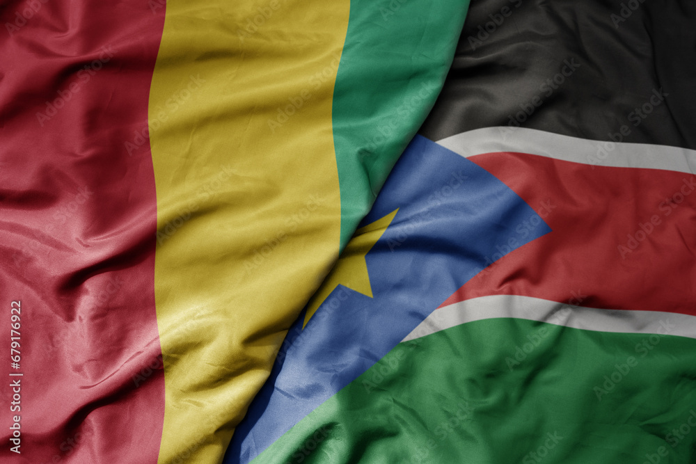 big waving national colorful flag of guinea and national flag of south sudan . big waving national colorful flag of guinea and national flag of south sudan .