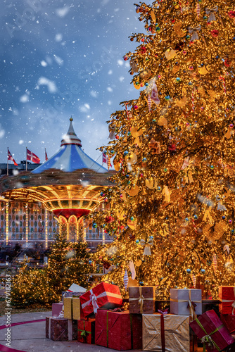 Christmas in Copenhagen, Tivoli Gardens, with a decorated tree, in front of a spinning Carousel, snowfall and bokeh lights, Denmark