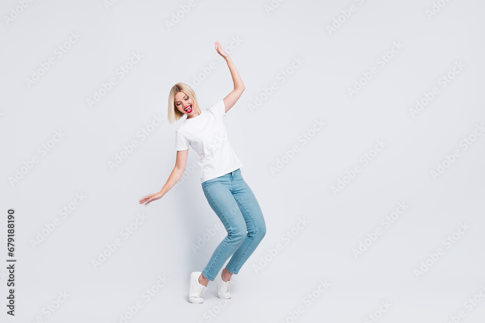 Full body photo of careless gorgeous woman wear stylish t-shirt falling look down at empty space isolated on gray color background Full body photo of careless gorgeous woman wear stylish t-shirt falling look down at empty space isolated on gray color background