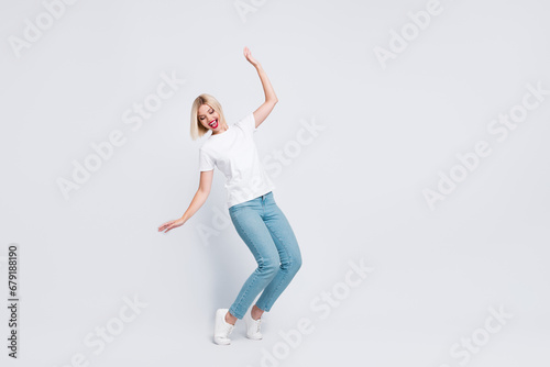 Full body photo of careless gorgeous woman wear stylish t-shirt falling look down at empty space isolated on gray color background